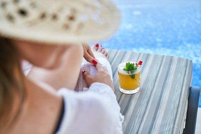 woman at resort hotel pool with drink